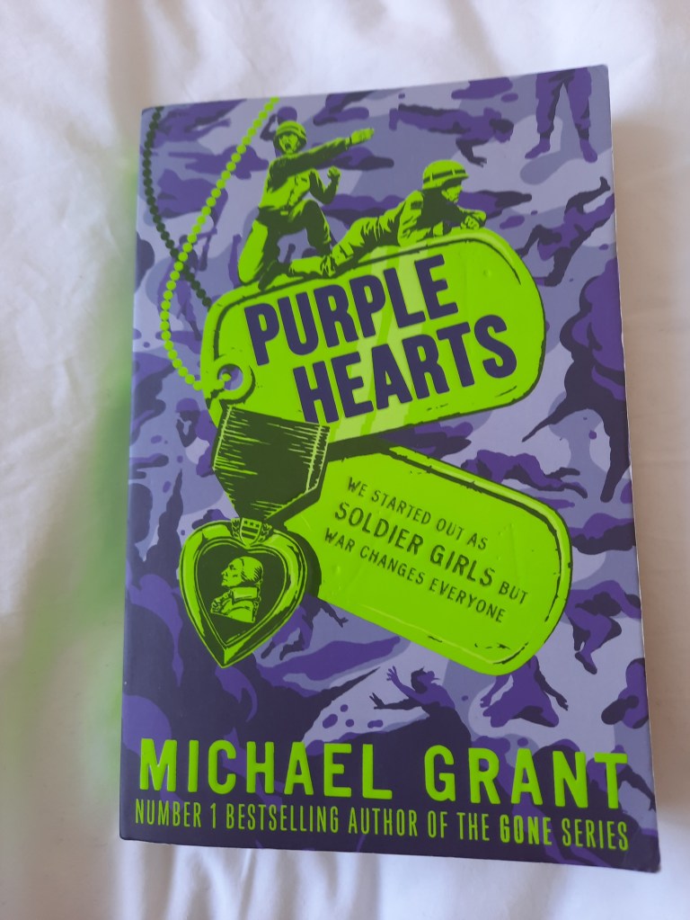 A copy of Silver Stars by Michael Grant resting on a white blanket.