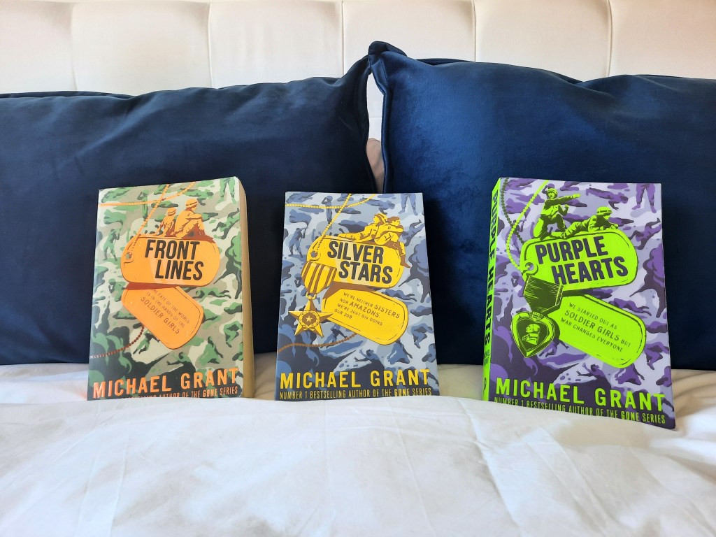 Michael Grant's World War II trilogy of books resting on some navy cushions. Front Lines, Silver Stars, and Purple Hearts.