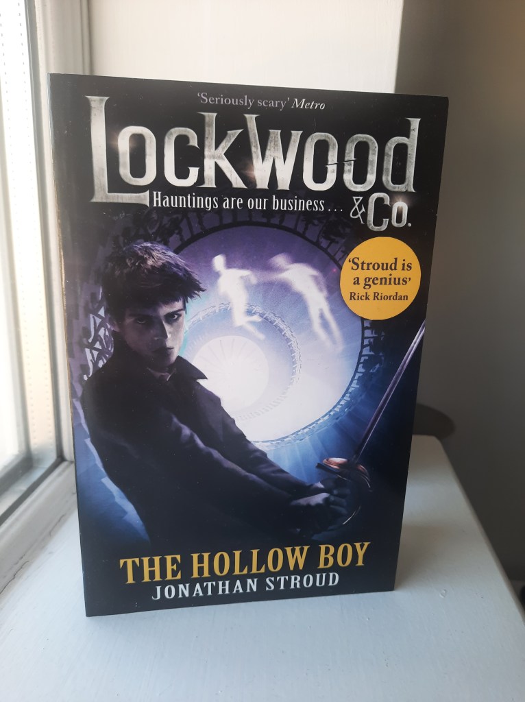 Softcopy book of Lockwood & Co. The Hollow Boy by Jonathan Stroud resting on a windowsill.